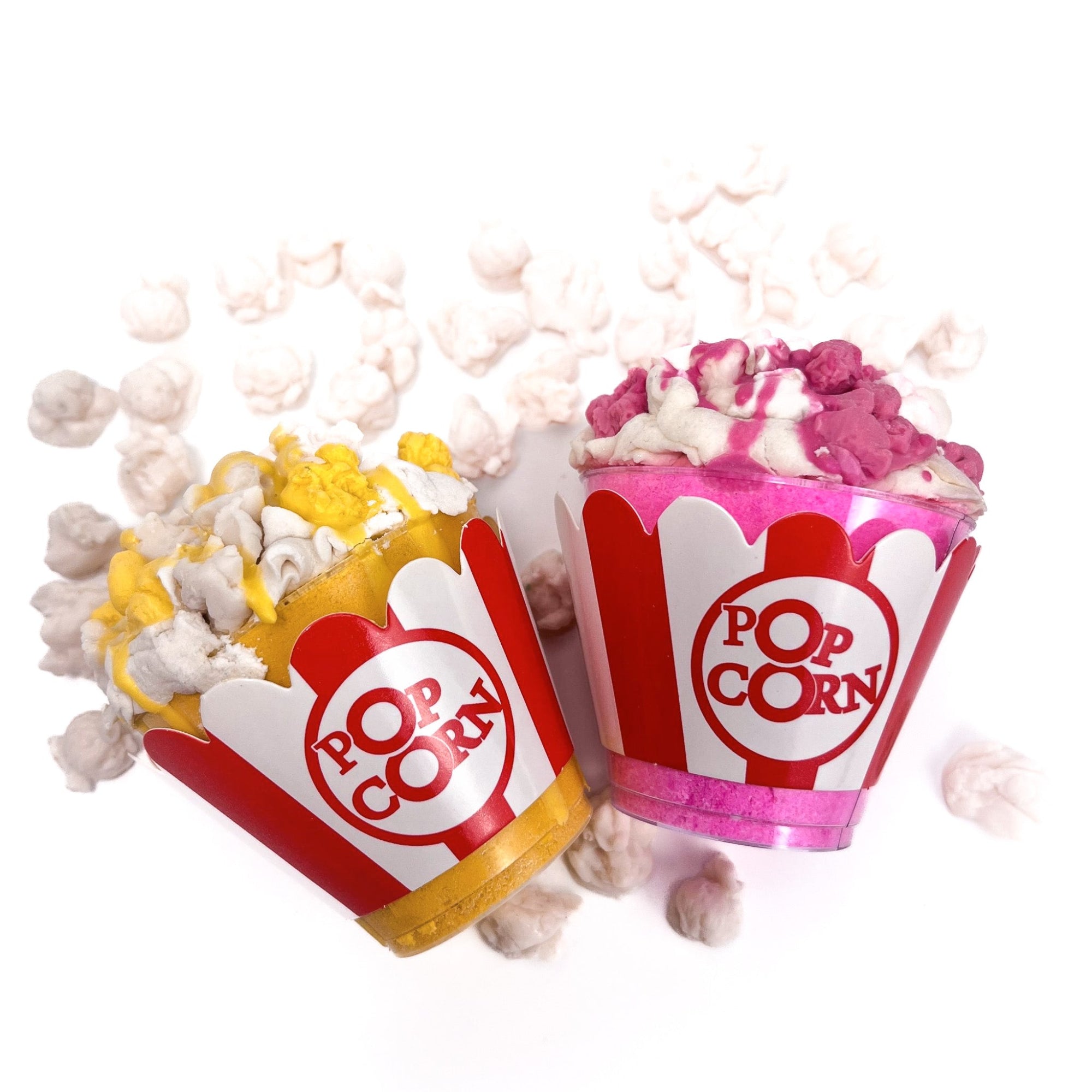 Two tubs of popcorn bath bombs. One yellow and white for butter, one pink and white for water melon! Topped with bubble frosting and popcorn soap embeds, then drizzled with same colored soap.