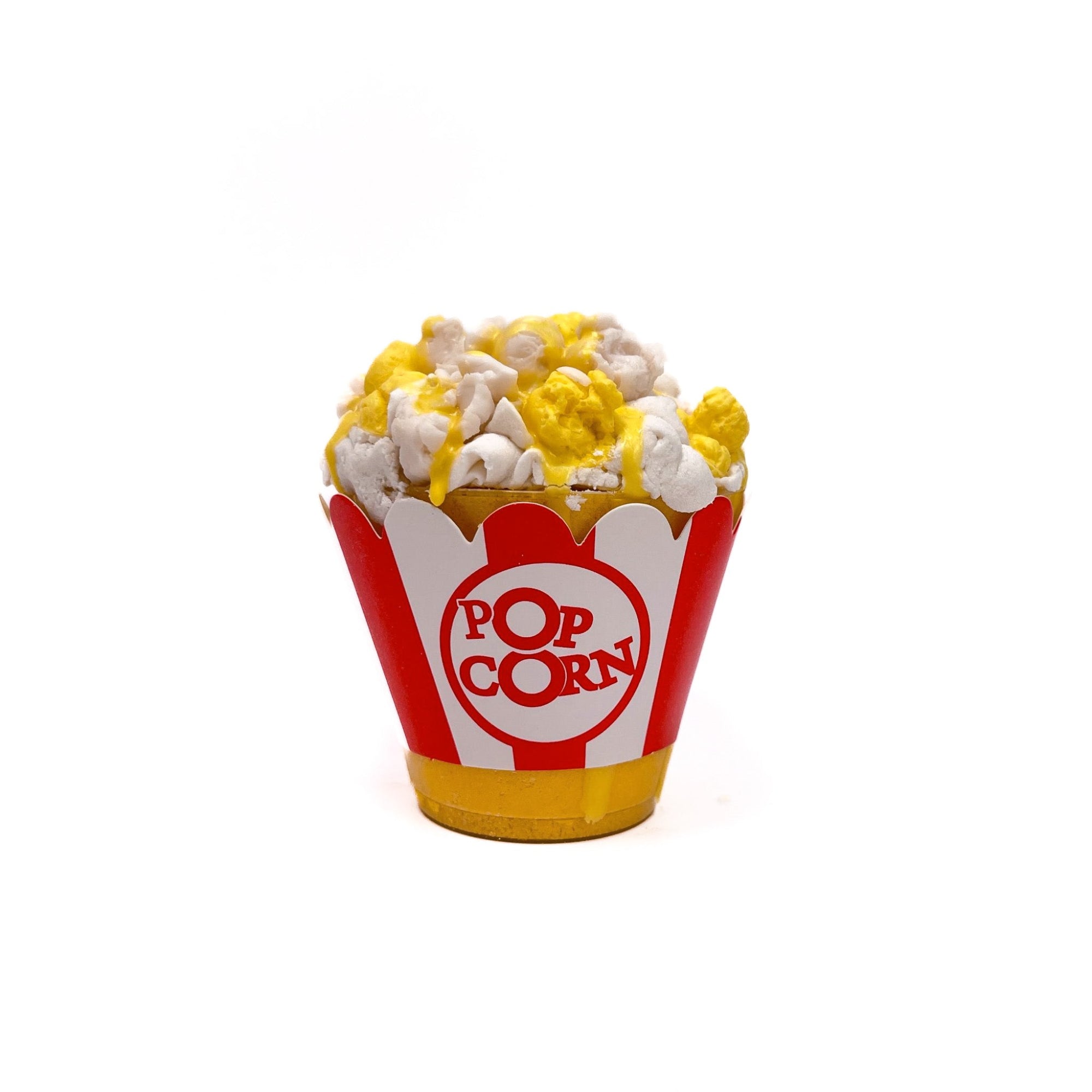 Yellow and white popcorn shaped soap on a movie popcorn container filled with yellow bath bomb. Red and white vertical striped wrapper with [POPCORN] written.