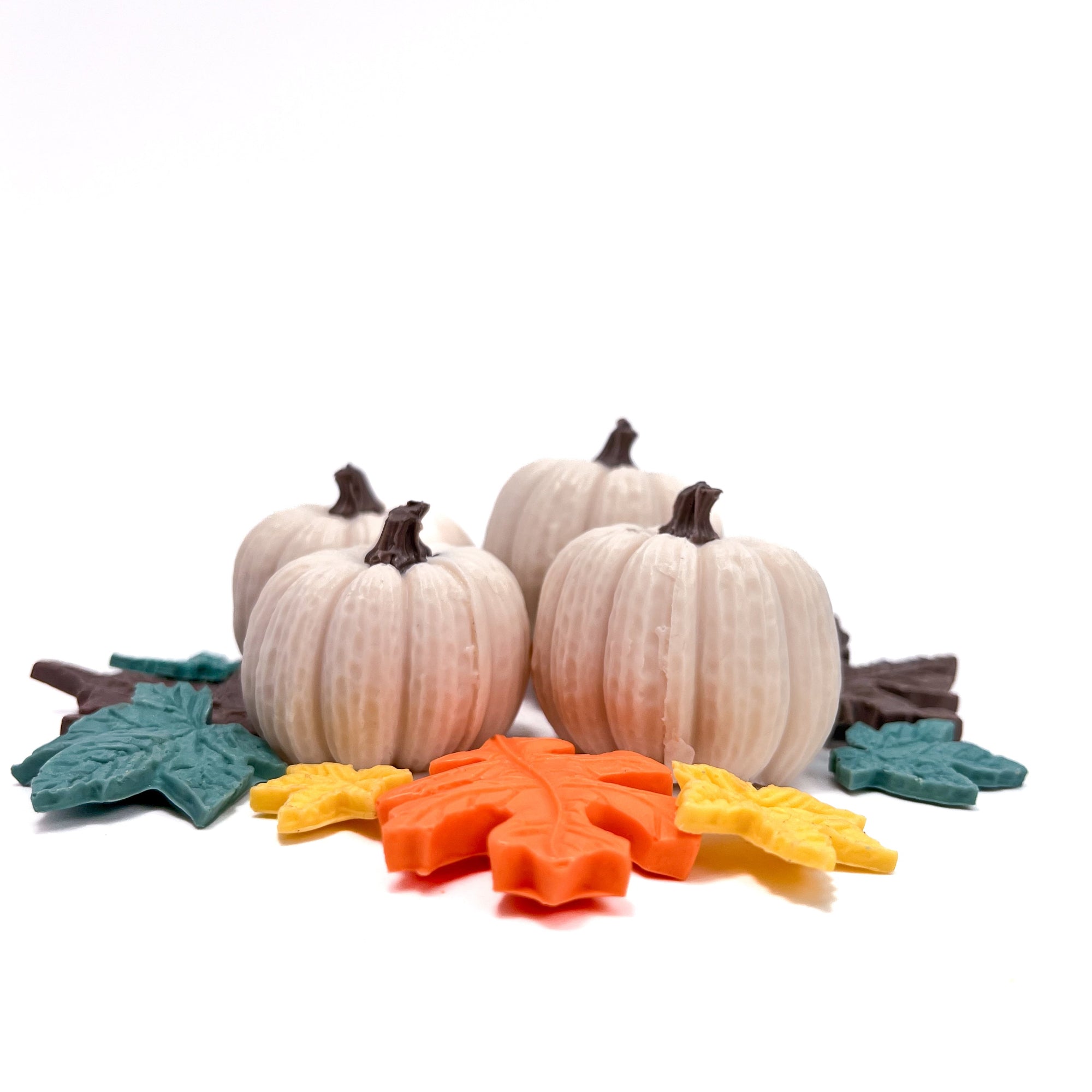 Four white soap pumpkins with decorative spoap leaves on a white background