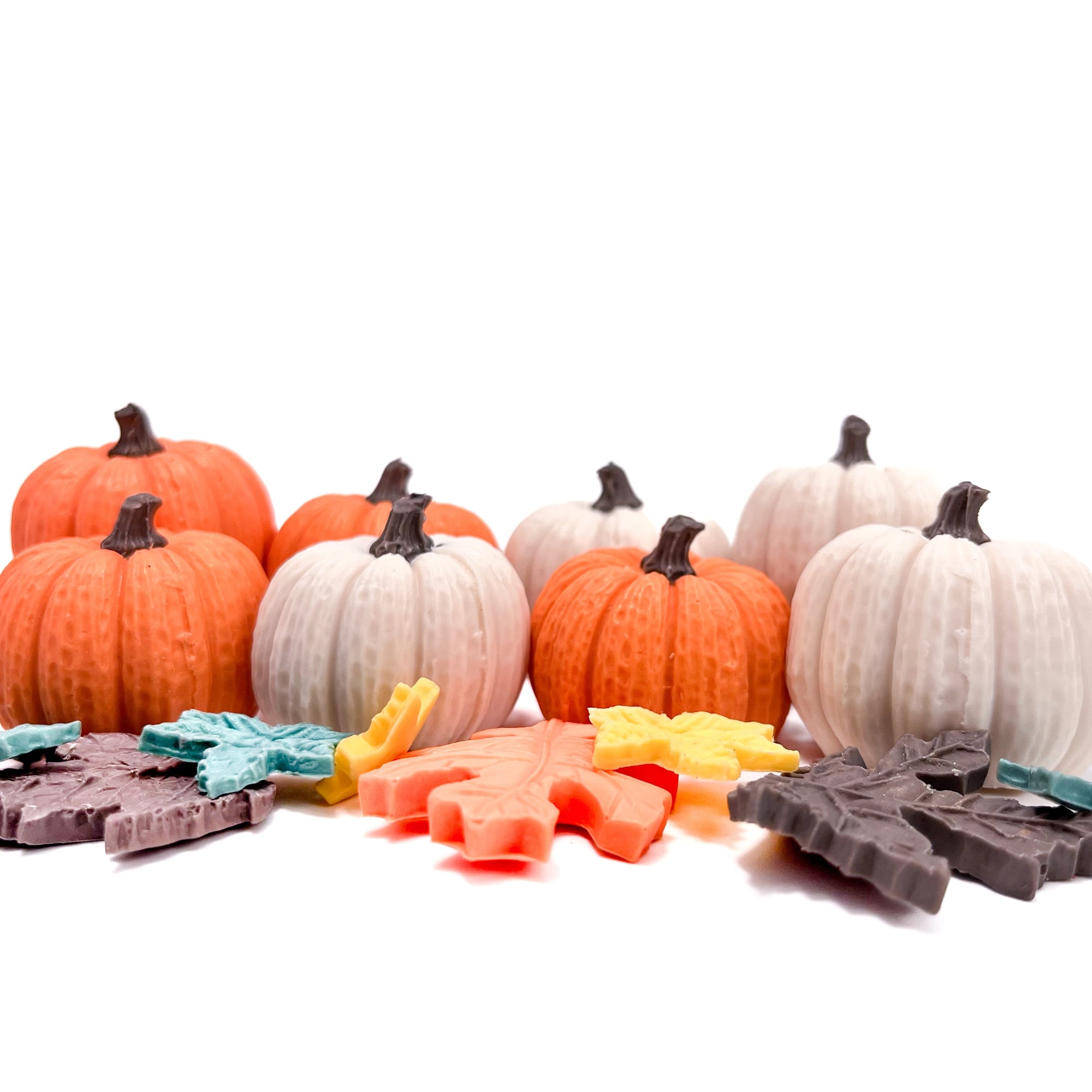 Colorful Halloween / fall themed soaps shaped like pumpkins and fall leaves on a white background. 