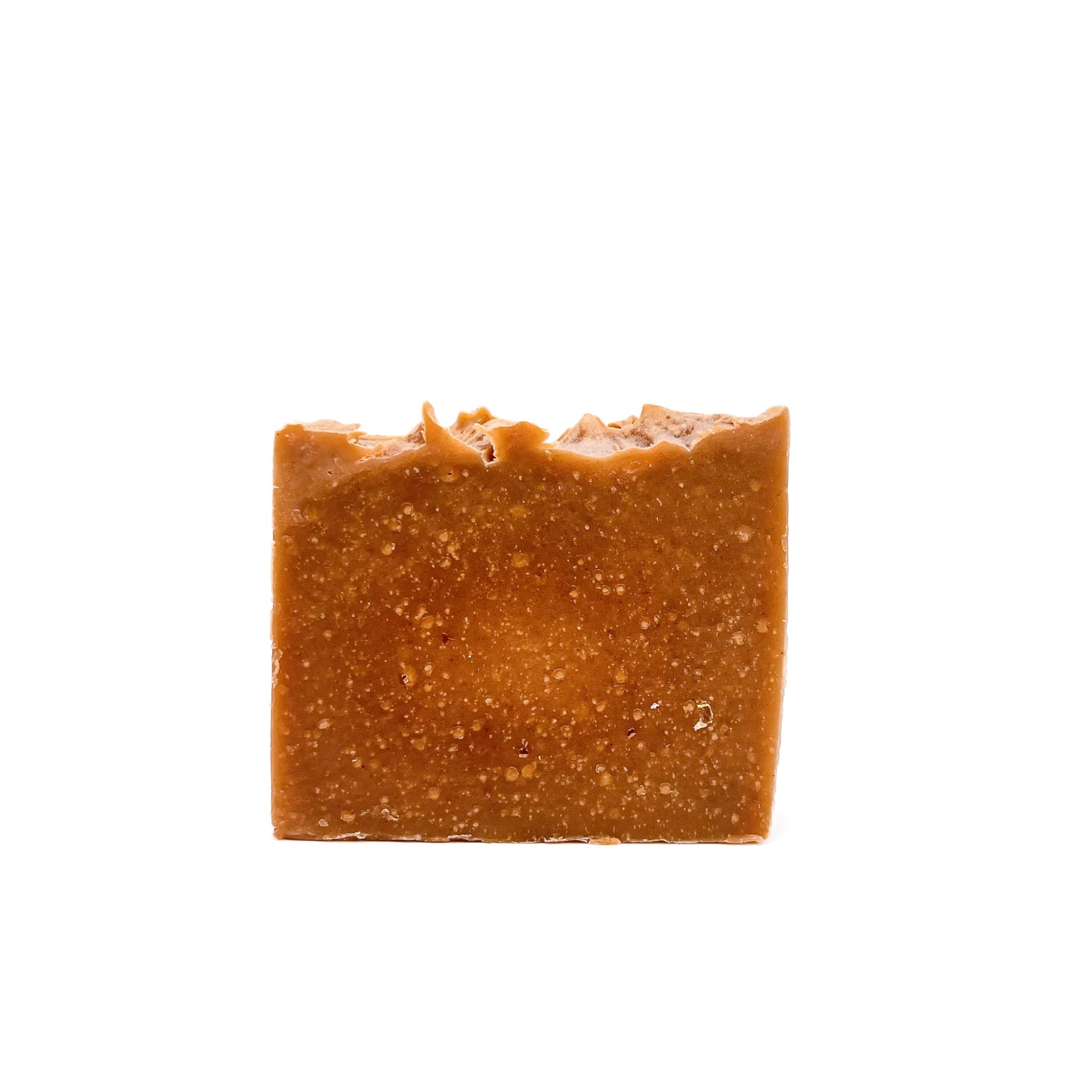 A bar of pumpkin spice scented turmeric colored handmade soap from Rusted Acre Soap Company.