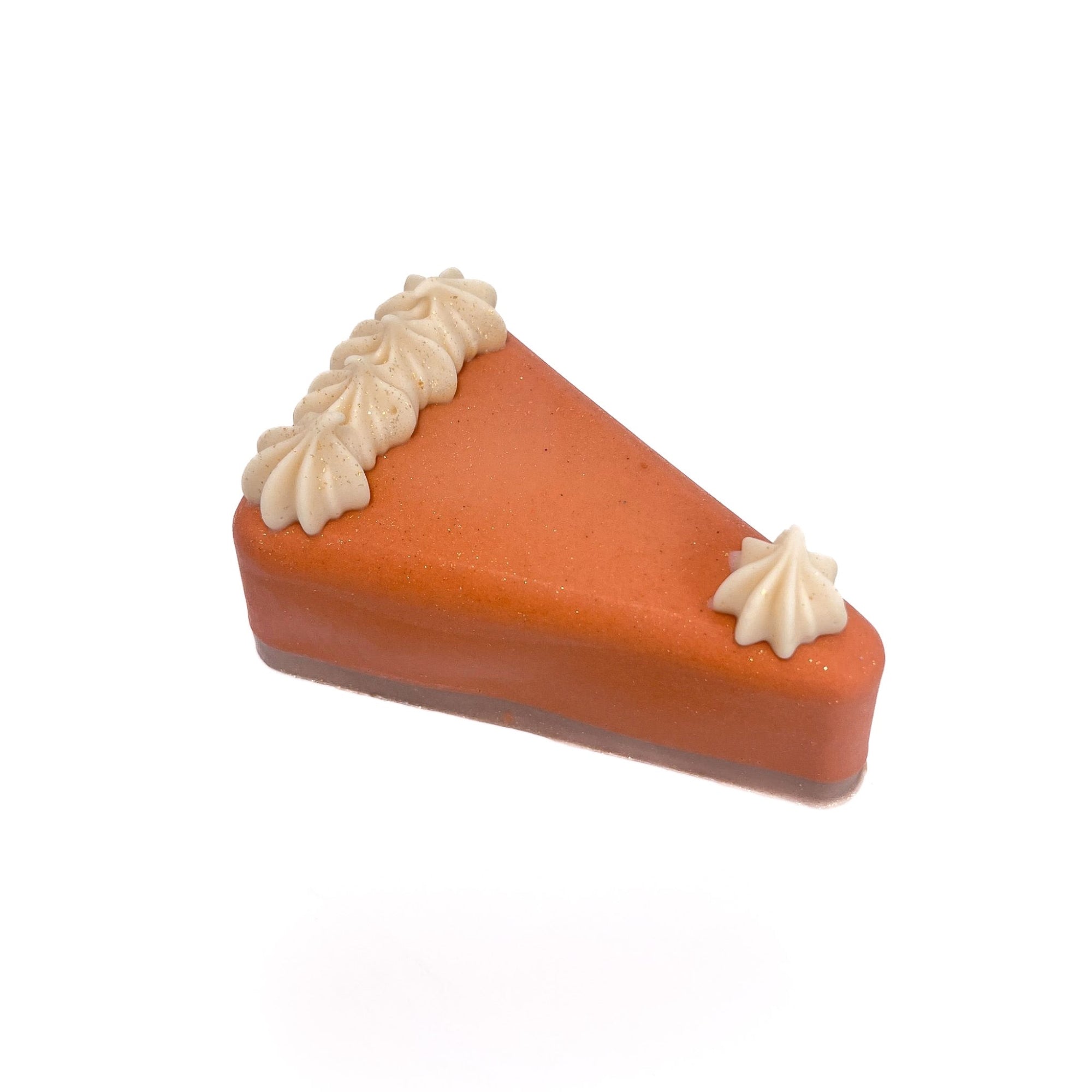 The top of Rusted Acre Soap Company's handmade pumpkin pie slice soap. Pumpkin colored filling, brown crust, small cream color soap puffs.