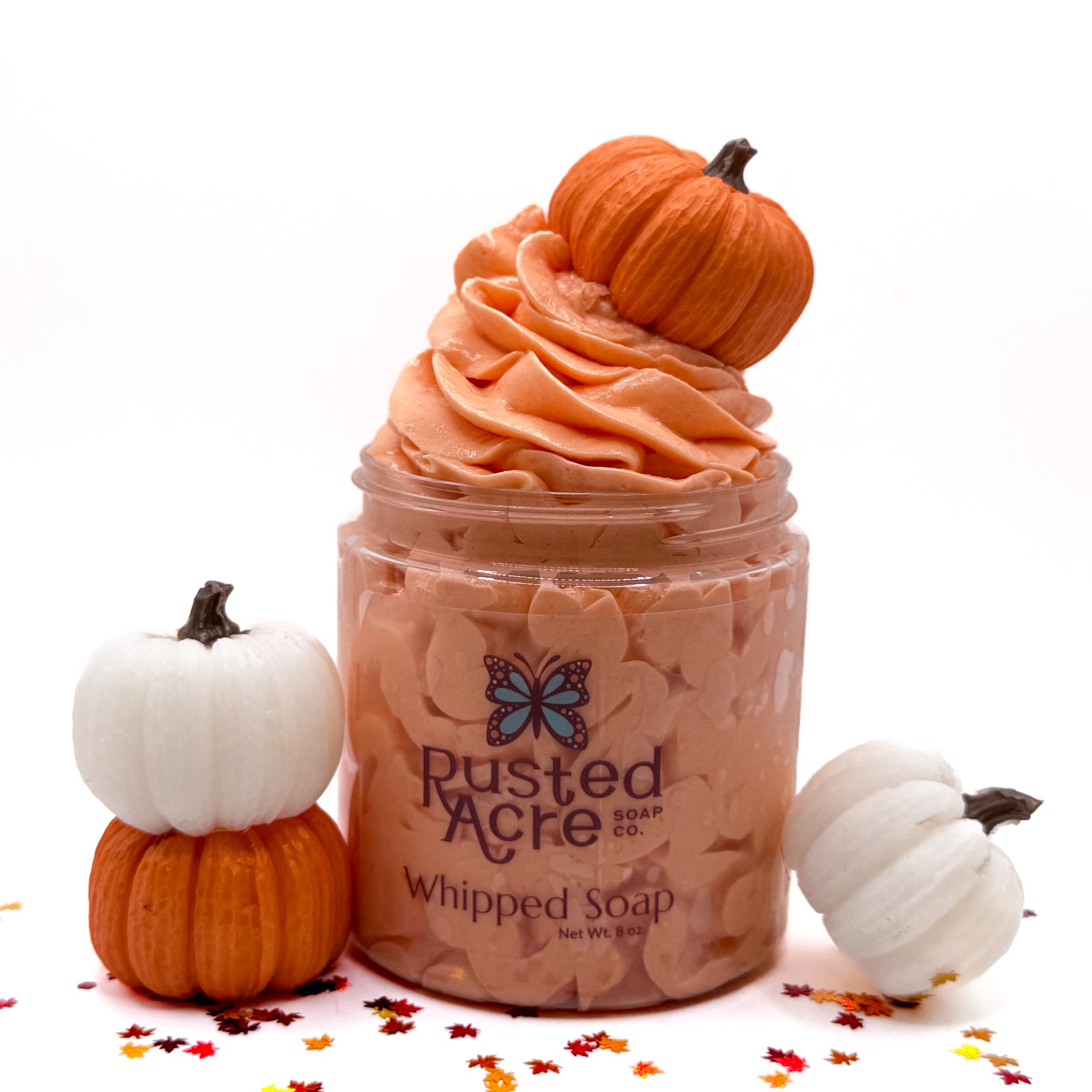 Jar of handmade pumpkin spice whipped soap with pumpkins on a white background.