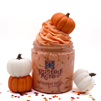 Jar of handmade pumpkin spice whipped soap with pumpkins on a white background.