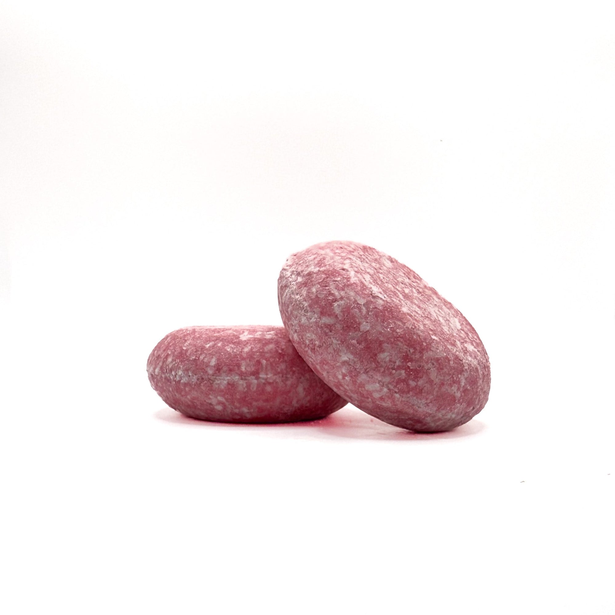 Two light pink zero waste shampoo bars in Raspberry scent from Rusted Acre Soap Company. 