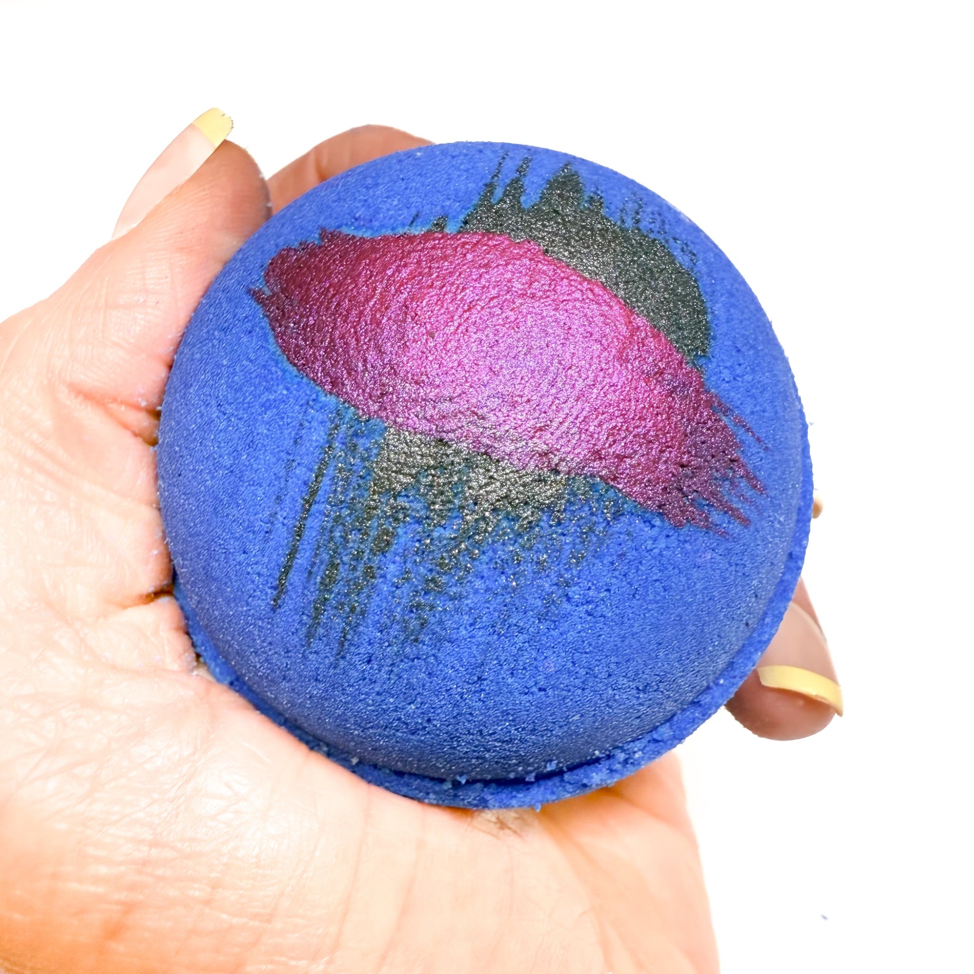 A hand made round purple bath bomb with hand painted brush  strokes on top for detail. Made by Rusted Acre Soap Co.