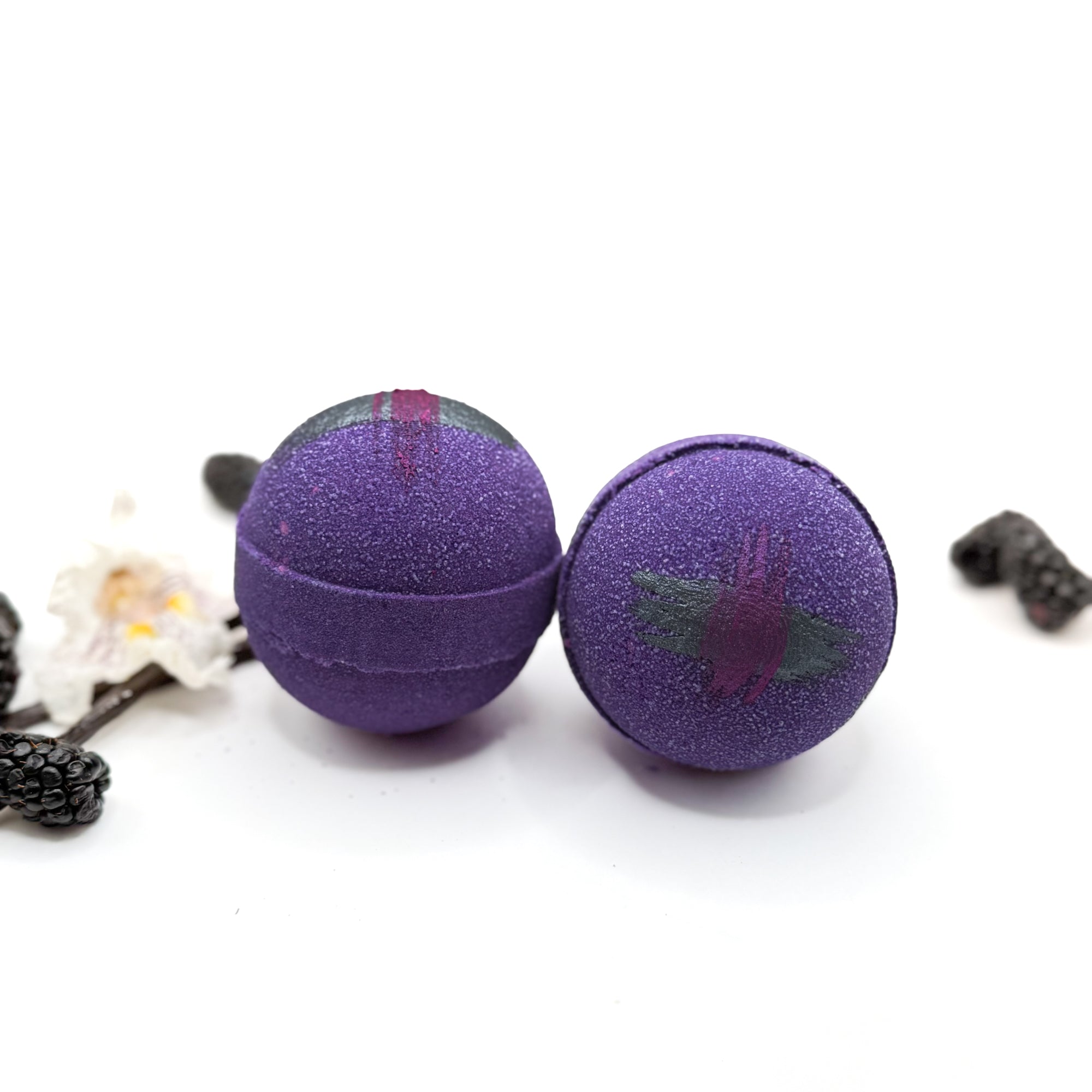 Two purple raspberry vanilla bath bombs with tartan pattern on a white background