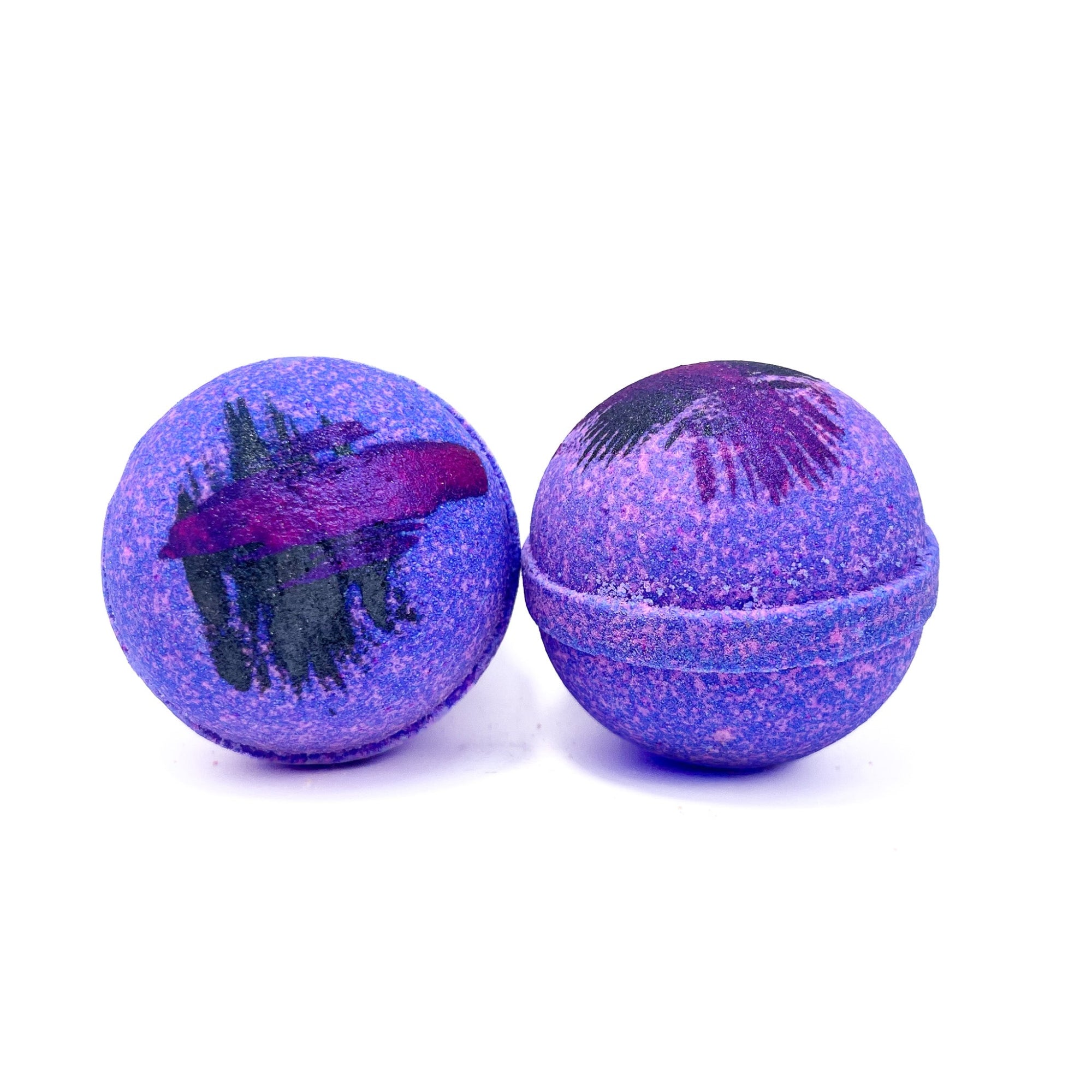 Two purple raspberry vanilla bath bombs, hand-painted purple streaks on top by Rusted Acre Soap Company.