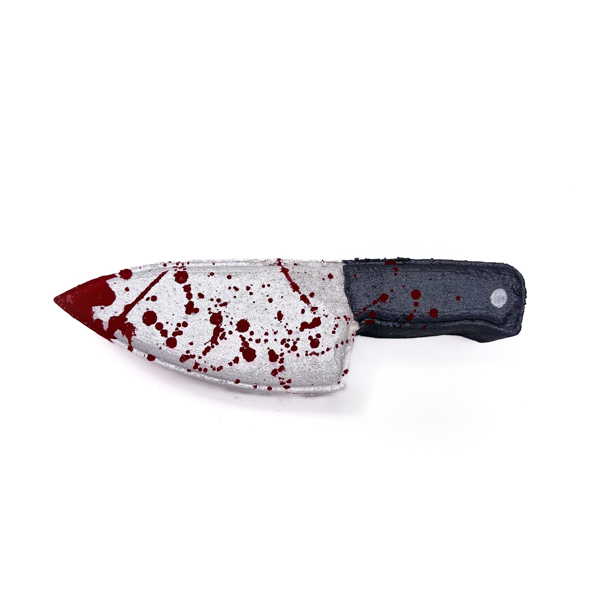 A knife shaped bath bomb with a hand-painted silver blade , and black handle with silver rivet. Splattered red like blood! Rusted Acre Soap Co,