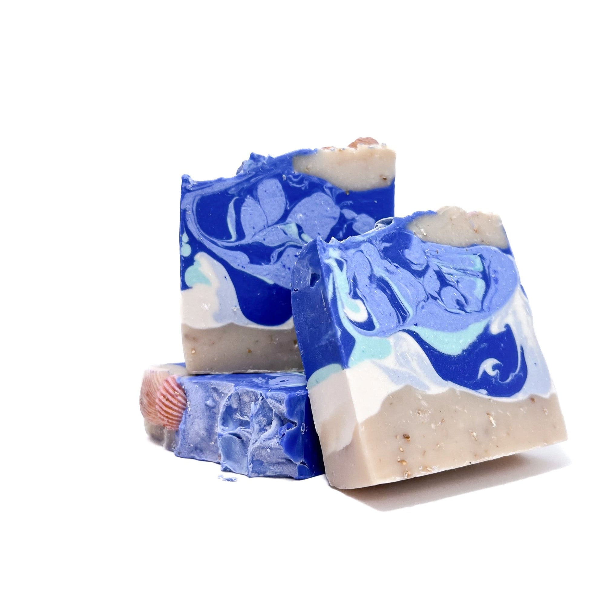 Three bars of Rusted Acre Soap Company's sea shell handmade soap. One flat, two upright.