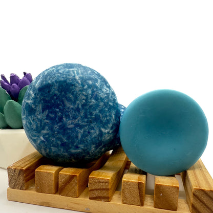 Blueberry Kiss zero waste Shampoo and Conditioner bar on a wood soap dish with a white background standing on side.
  