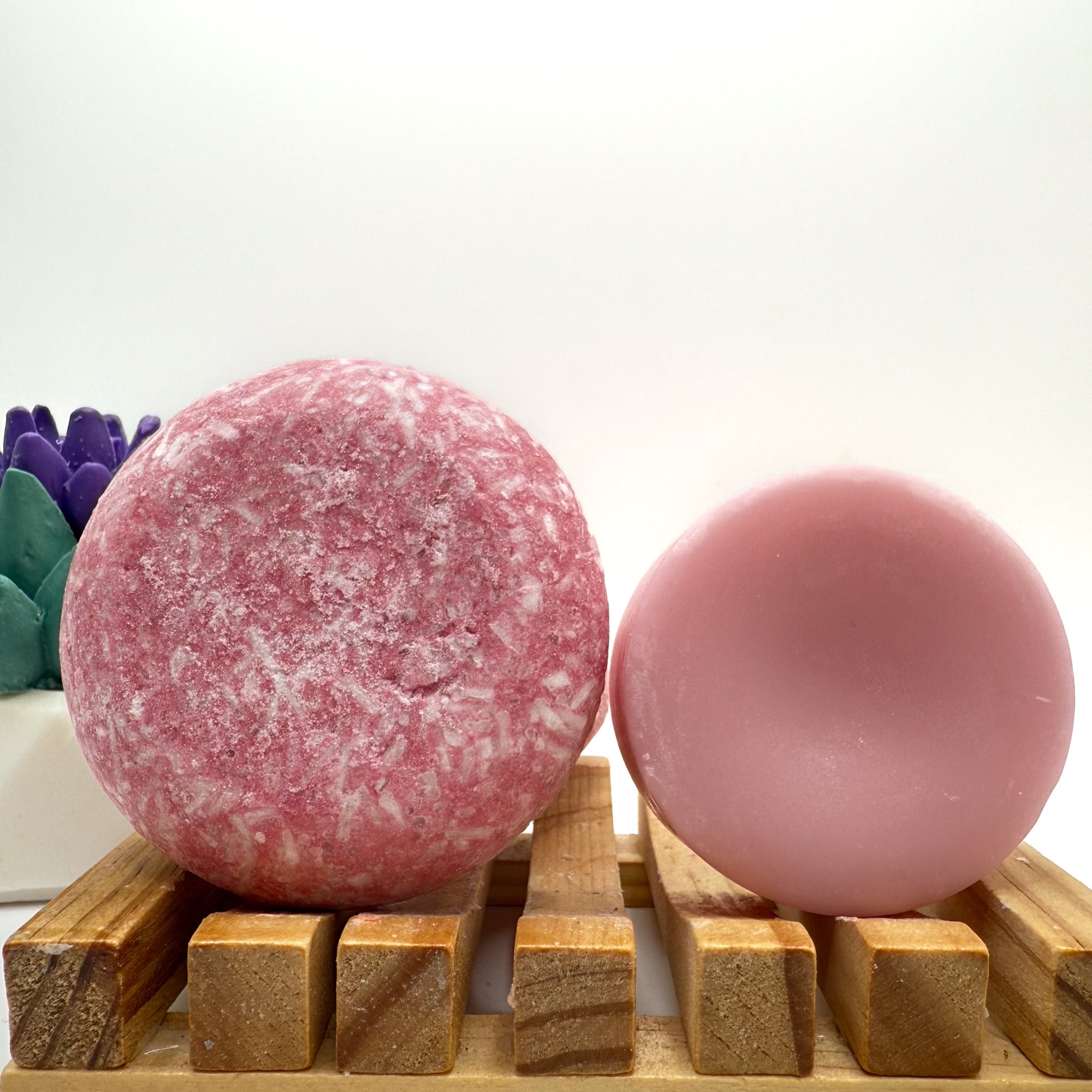 Raspberry Lime zero waste Shampoo and Conditioner bar on a wood soap dish with a white background standing on side.