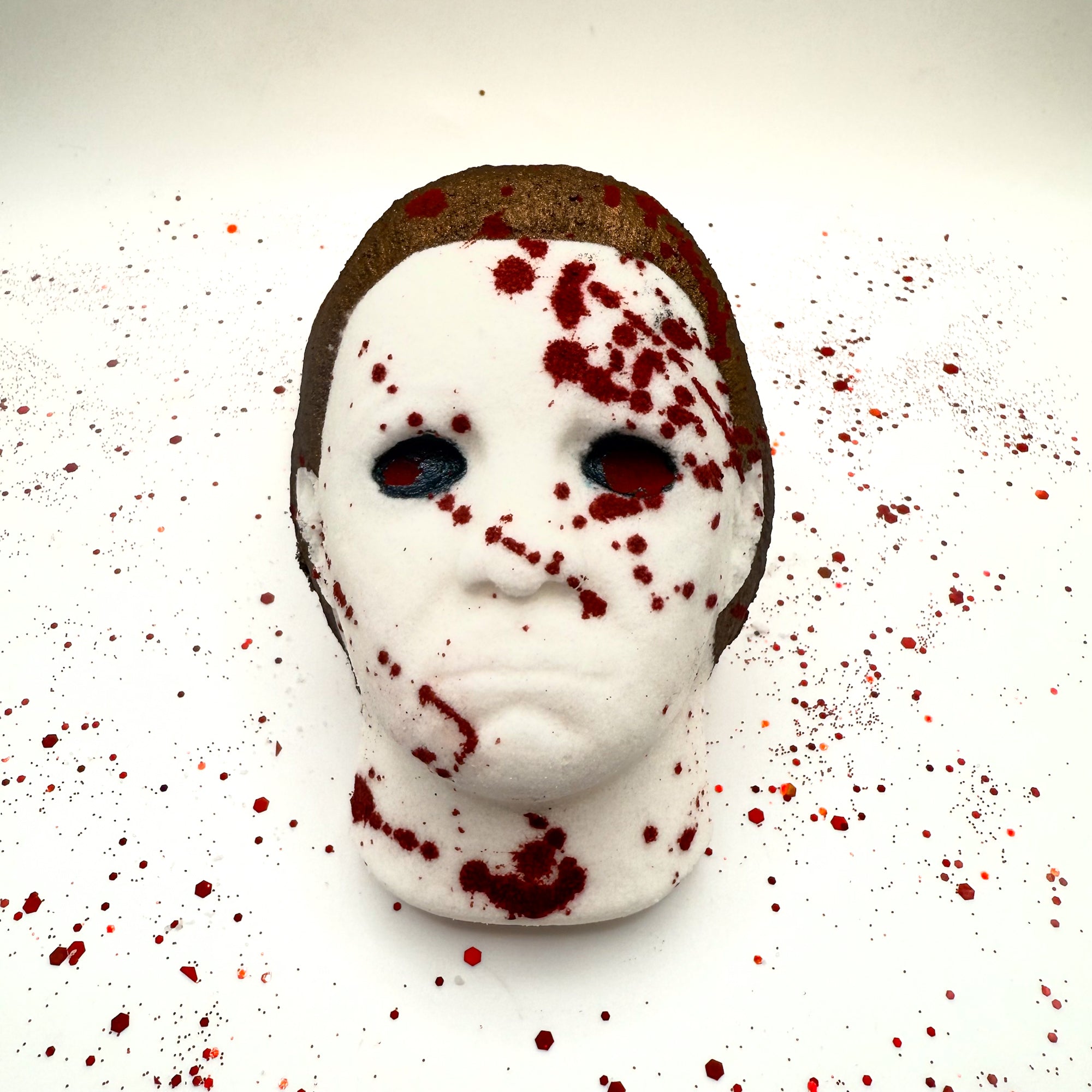 Front view of Silent Stalker horror bath bomb with intense blood splatter across the mask and background.
