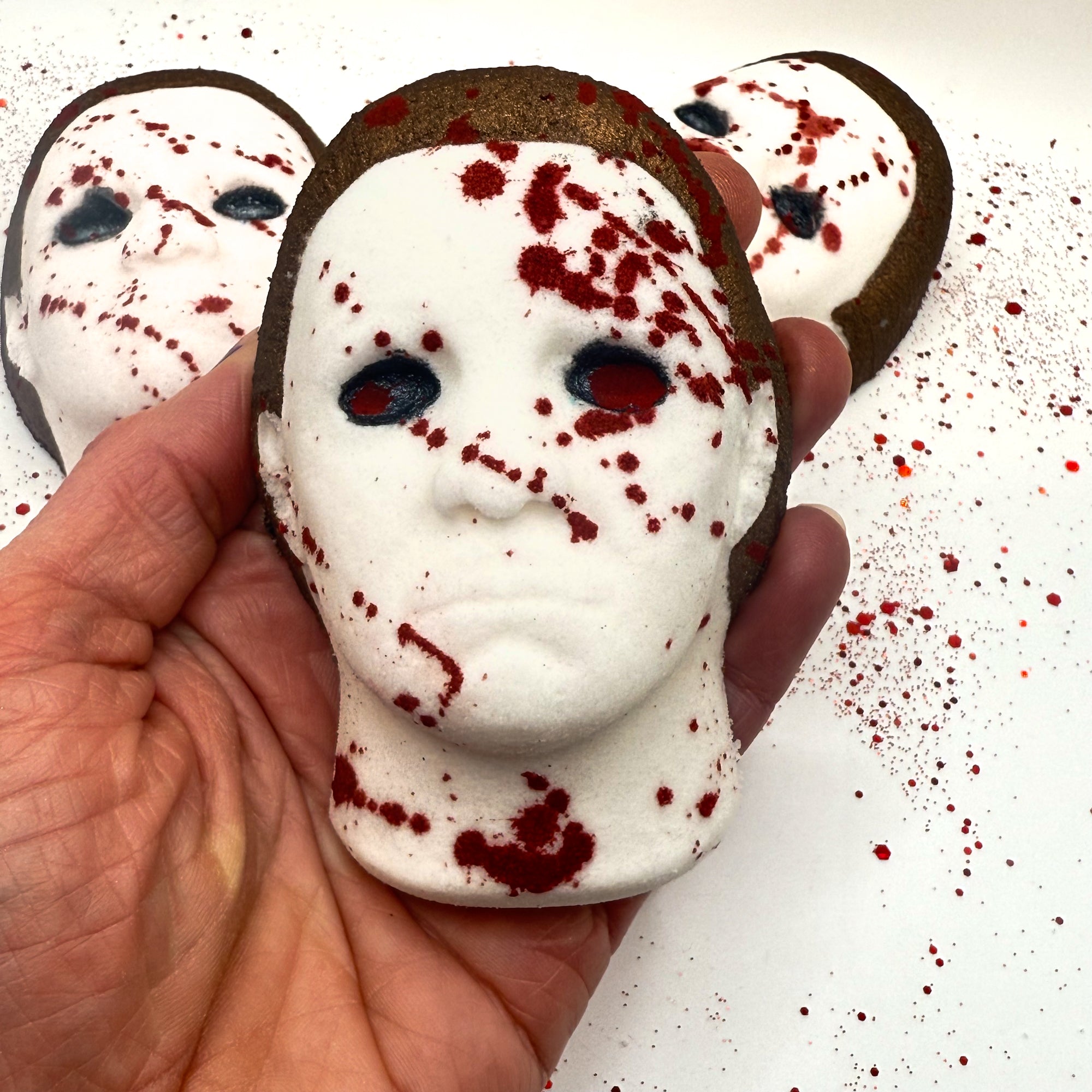 Silent Stalker horror-inspired bath bomb held in hand, featuring splattered blood details and brown hair.