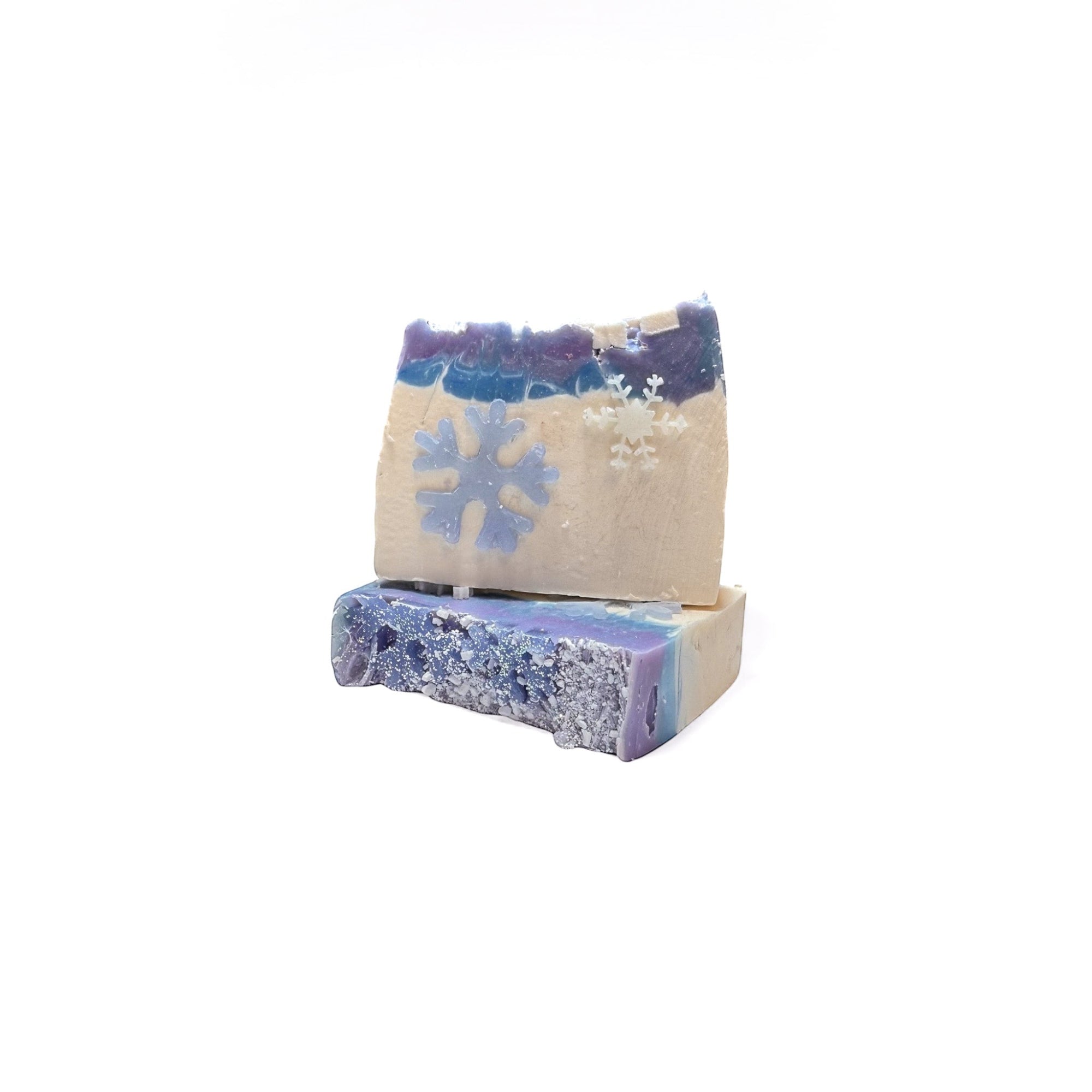 Two bars of handmade Snow Queen bar soap. White on the bottom third, and purple and blue swirl top third. Snowflake soap embeds on front.