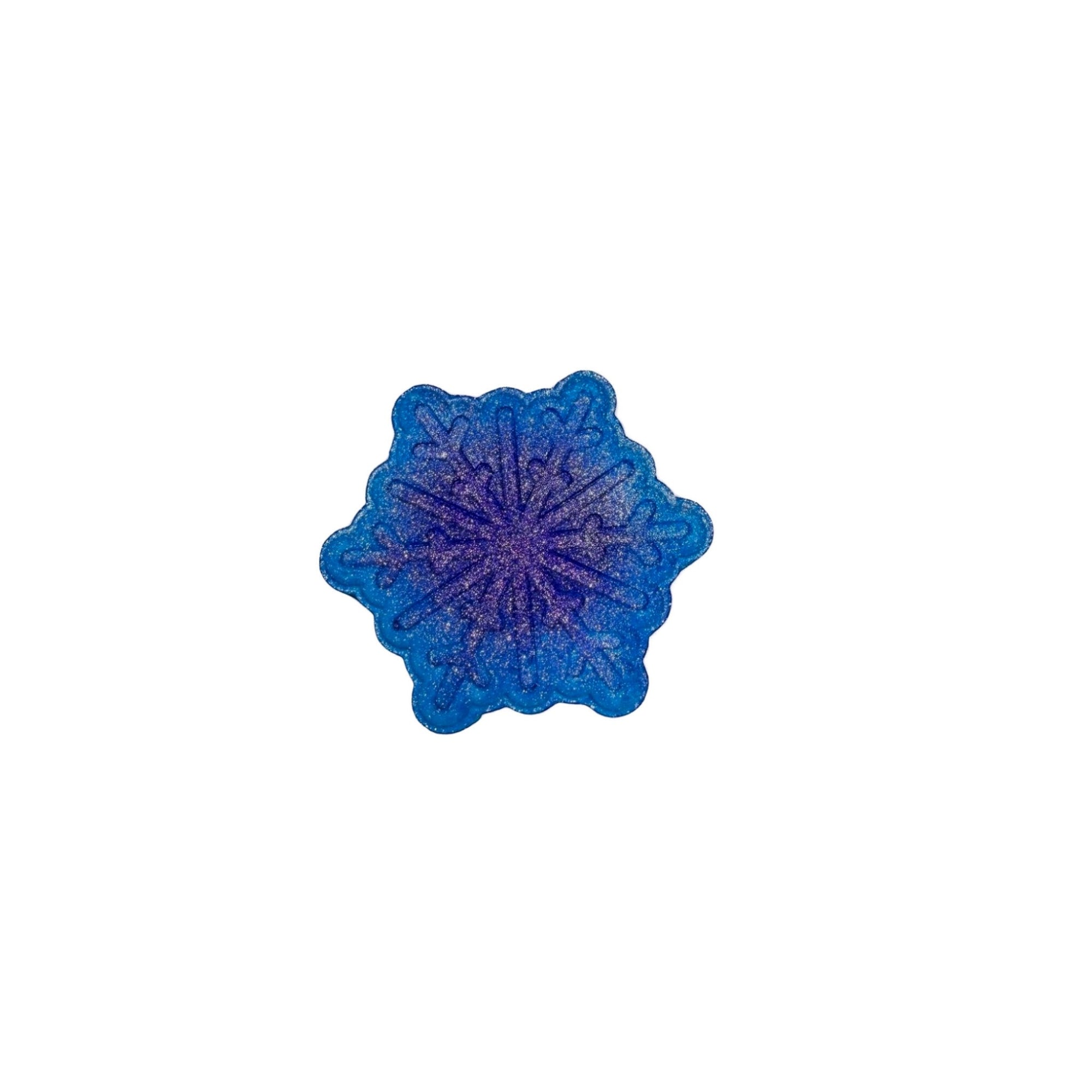 A blue snowflake bath bomb from Rusted Acre Soap Co. Air-brushed darker blue dot in the center.