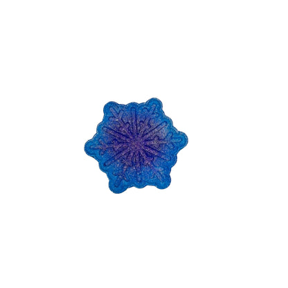 A blue snowflake bath bomb from Rusted Acre Soap Co. Air-brushed darker blue dot in the center.