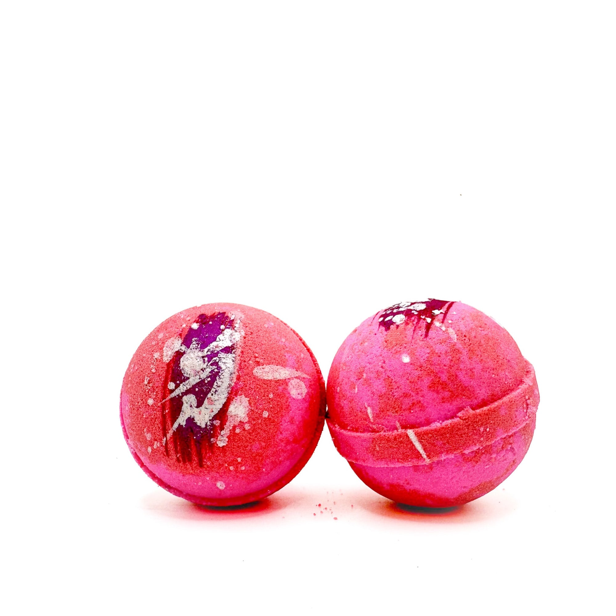 Two pink and white swirled round bath bombs side by side, hand-painted dark pink streaks splattered with silver mica.