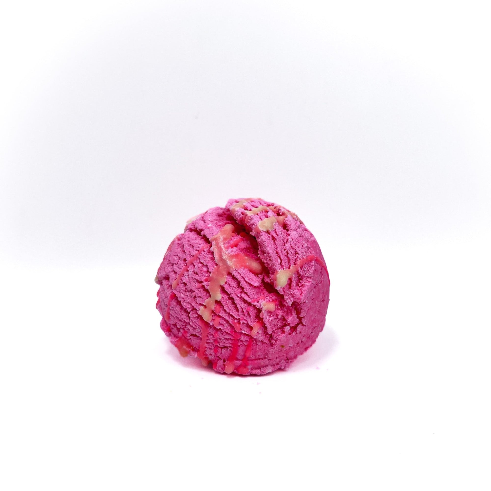 A scoop of pink bubble bar resembling a scoop of ice cream. Drizzled with pink cocoa butter!