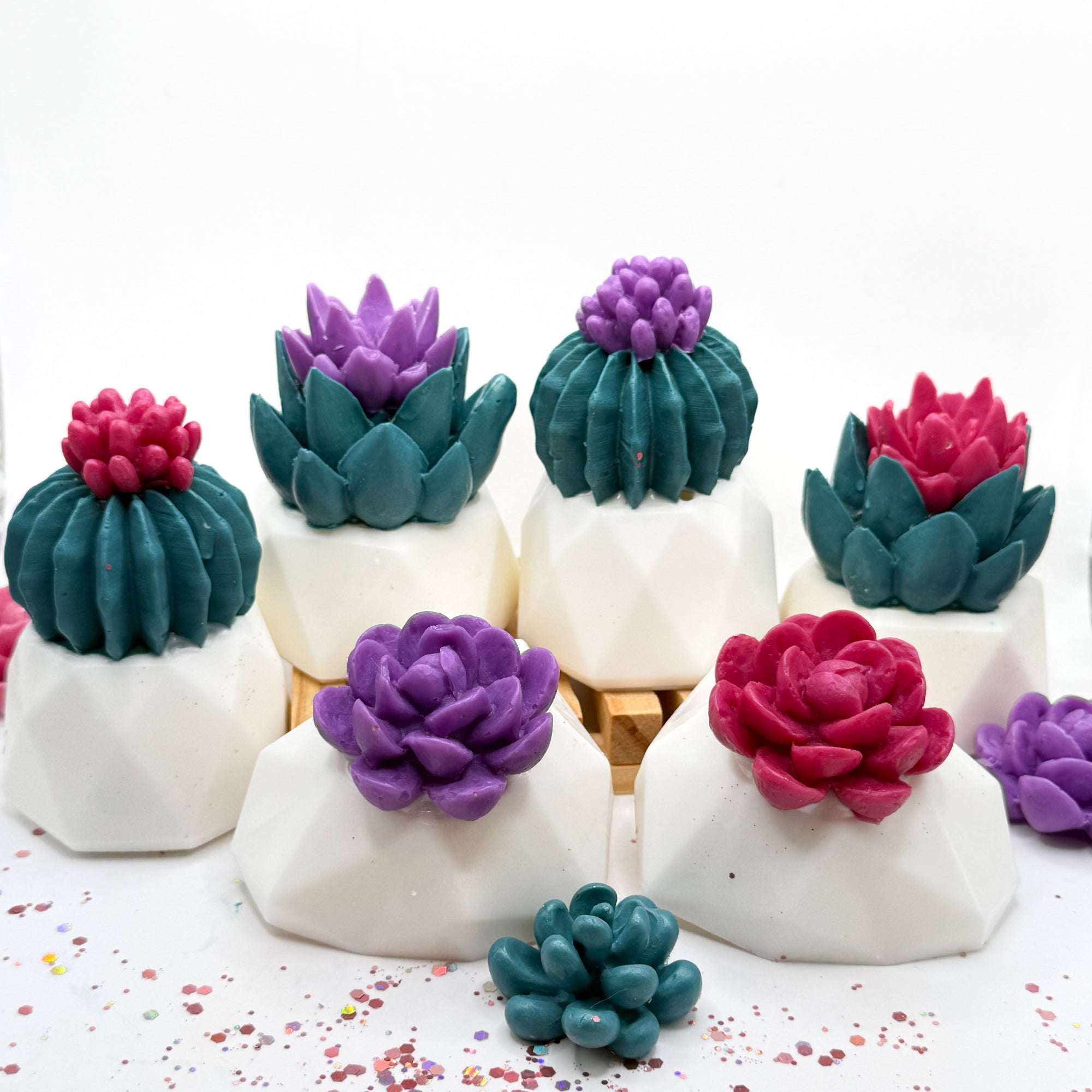 6 mixed color decorative succulent soaps. 3 pink and 3 purple flowers on white soap pots handmade by Rusted Acre Soap Co.