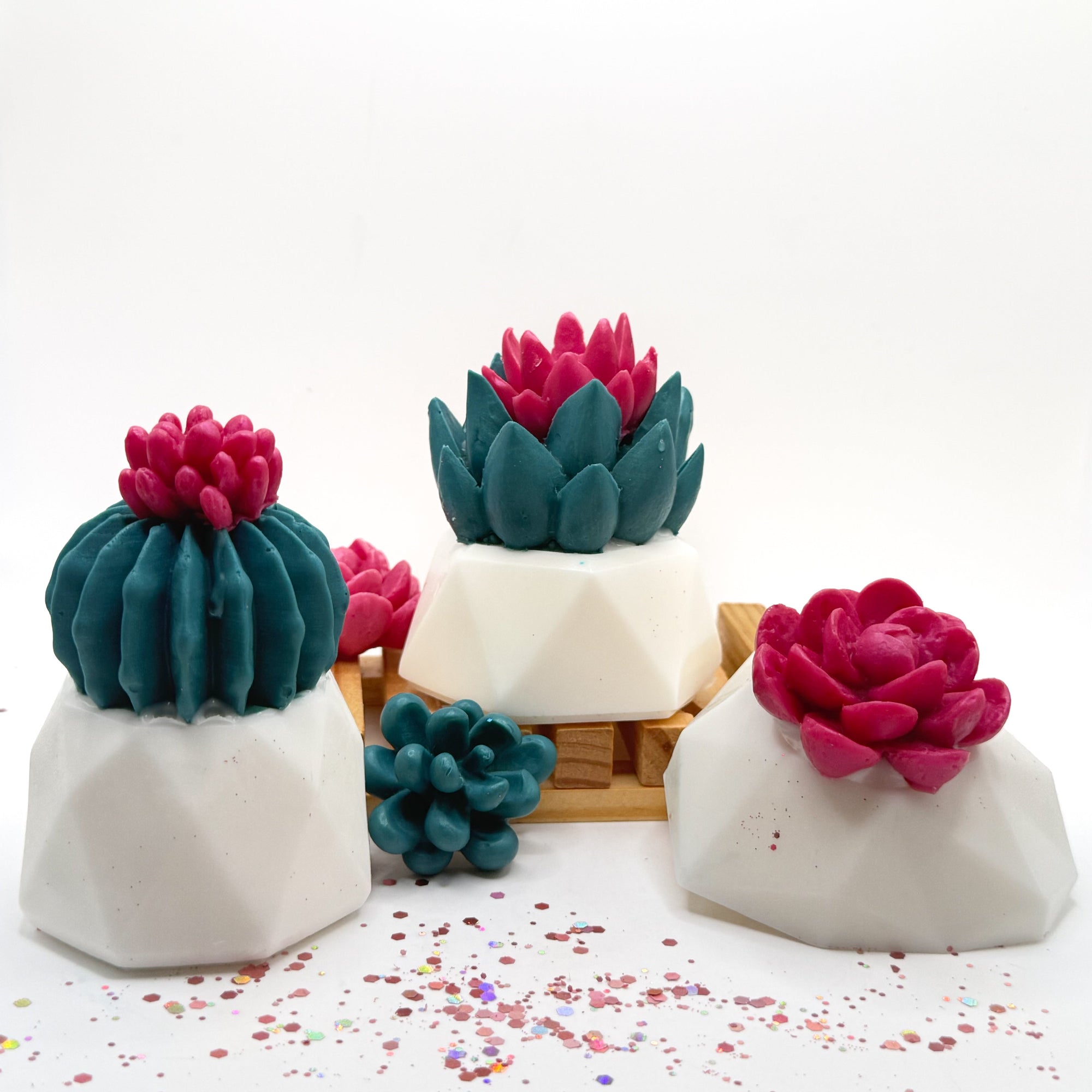 3 green succulent decorative soaps with pink flowers and white flower pots on a wooden soap lift, handmade by Rusted Acre Soap Co.