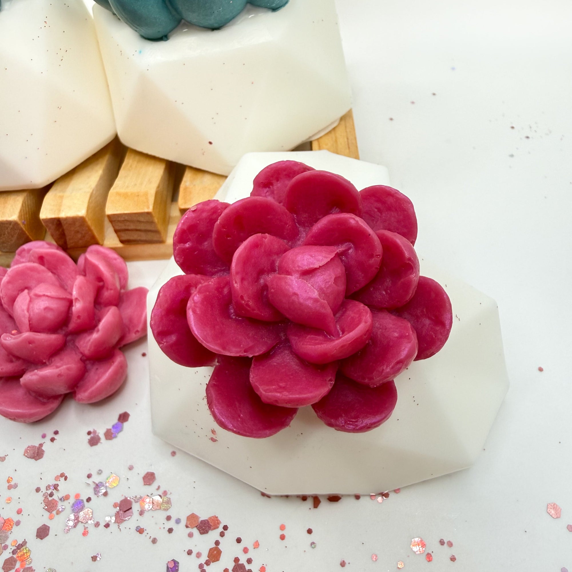 Pink succulent-shaped soap on a white heart shaped soap pot with wooden soap lift handmade by Rusted Acre Soap Co.
