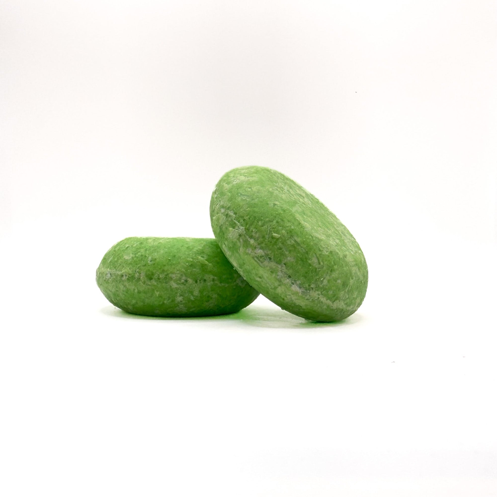 Two green zero waste shampoo bars in summer melon scent from Rusted Acre Soap Company. 