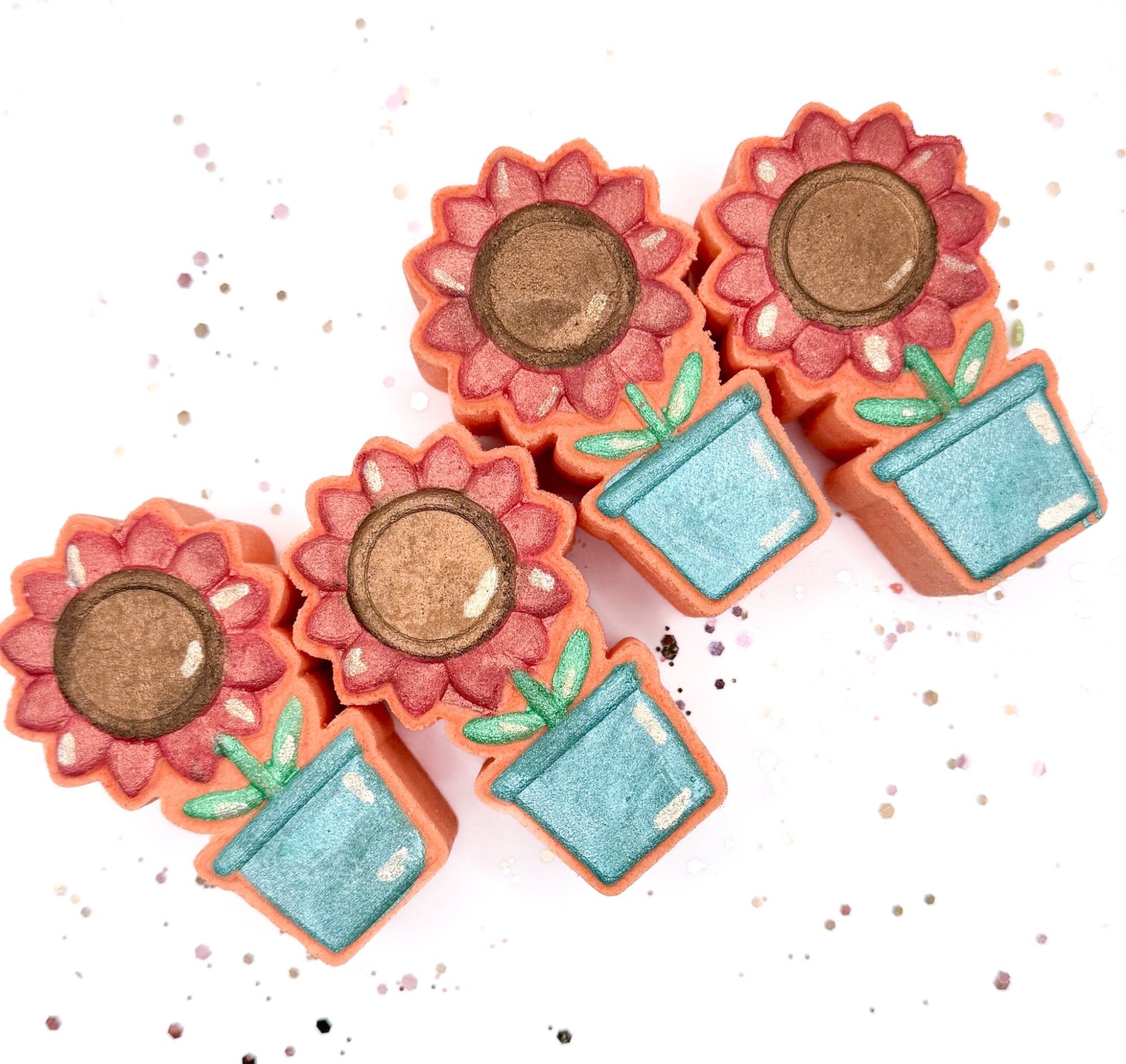 Hand painted Sunflower Pot bath bomb made by Rusted Acre Soap Company. Peach in color with a.  pink/coral sunflower. Multiple sunflower pots laying down flat for a group overhead picture.