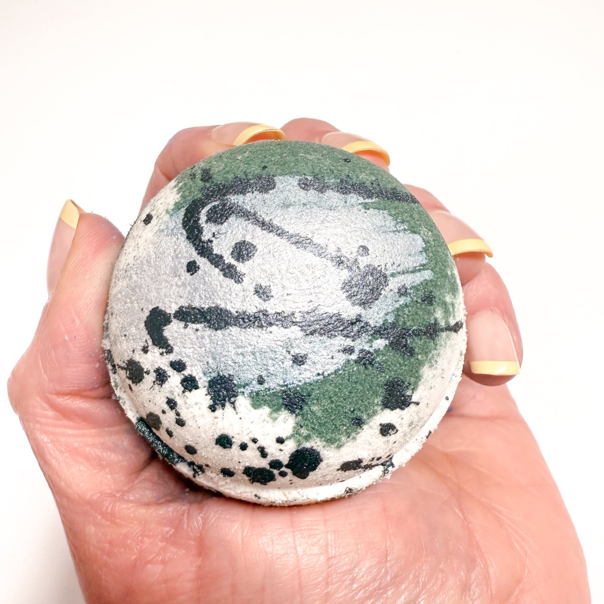 Black and white Tuxedo Bath Bomb, hand-painted with a sleek design, held in hand, made by Rusted Acre Soap Co. 