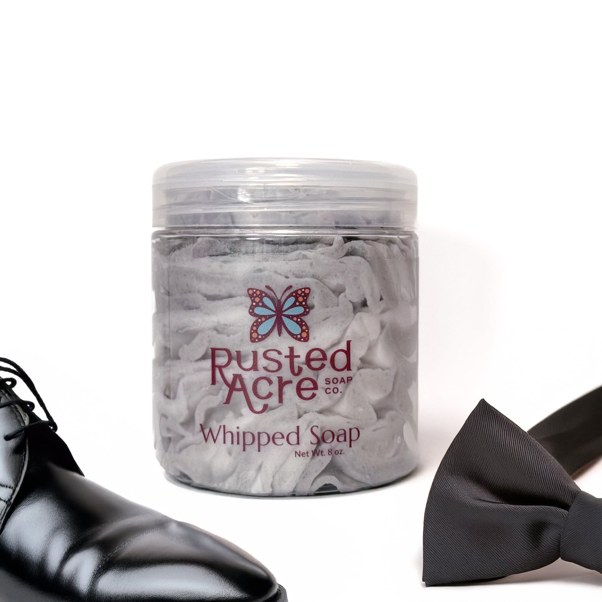 Jar of Rusted Acre Soap Company's vegan Tuxedo whipped soap. Gray and white soap in a reusable plastic jar in a lifestyle setting. 