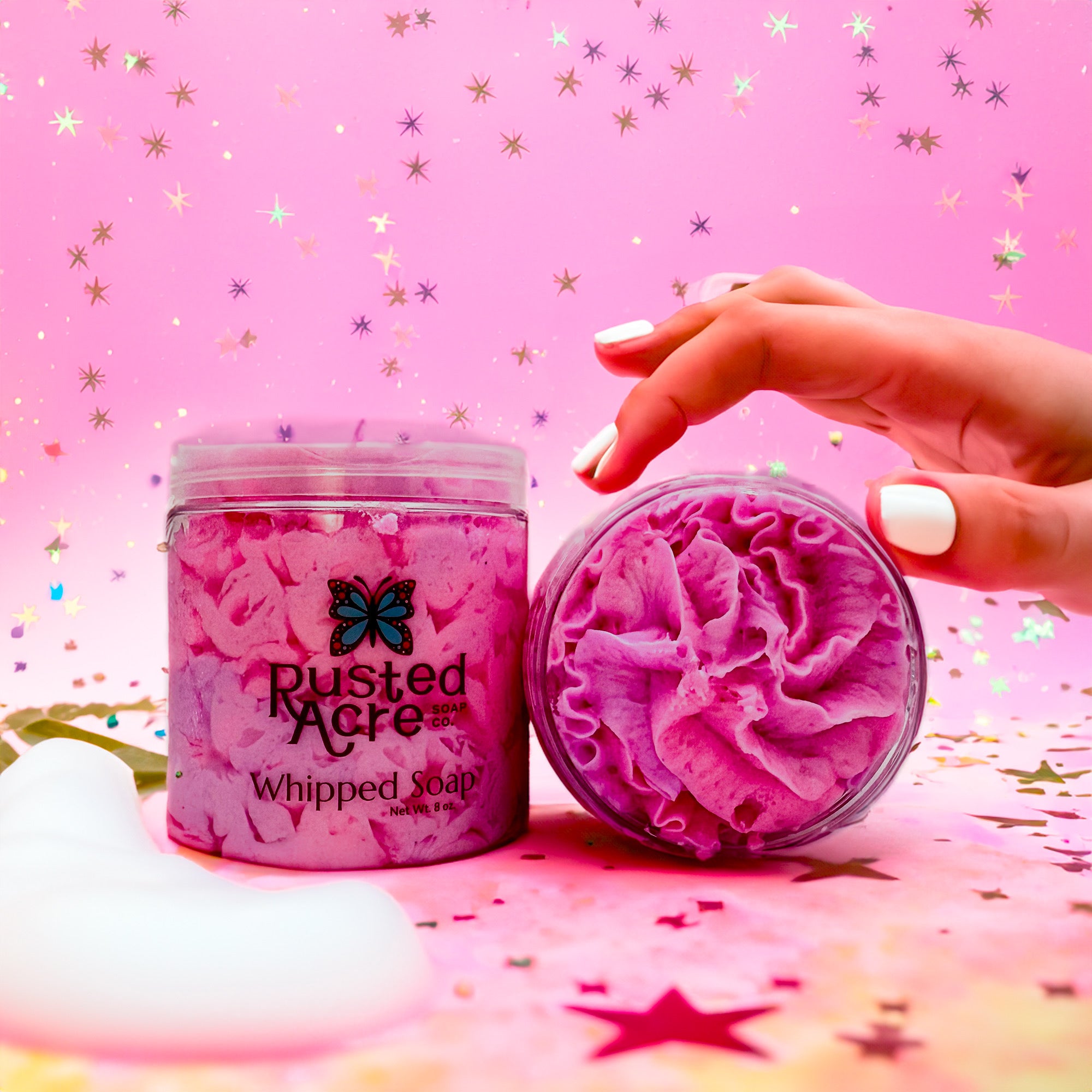 Two jars of Rusted Acre Soap Company’s Unicorn Dream whipped soap front and top view in a lifestyle setting.