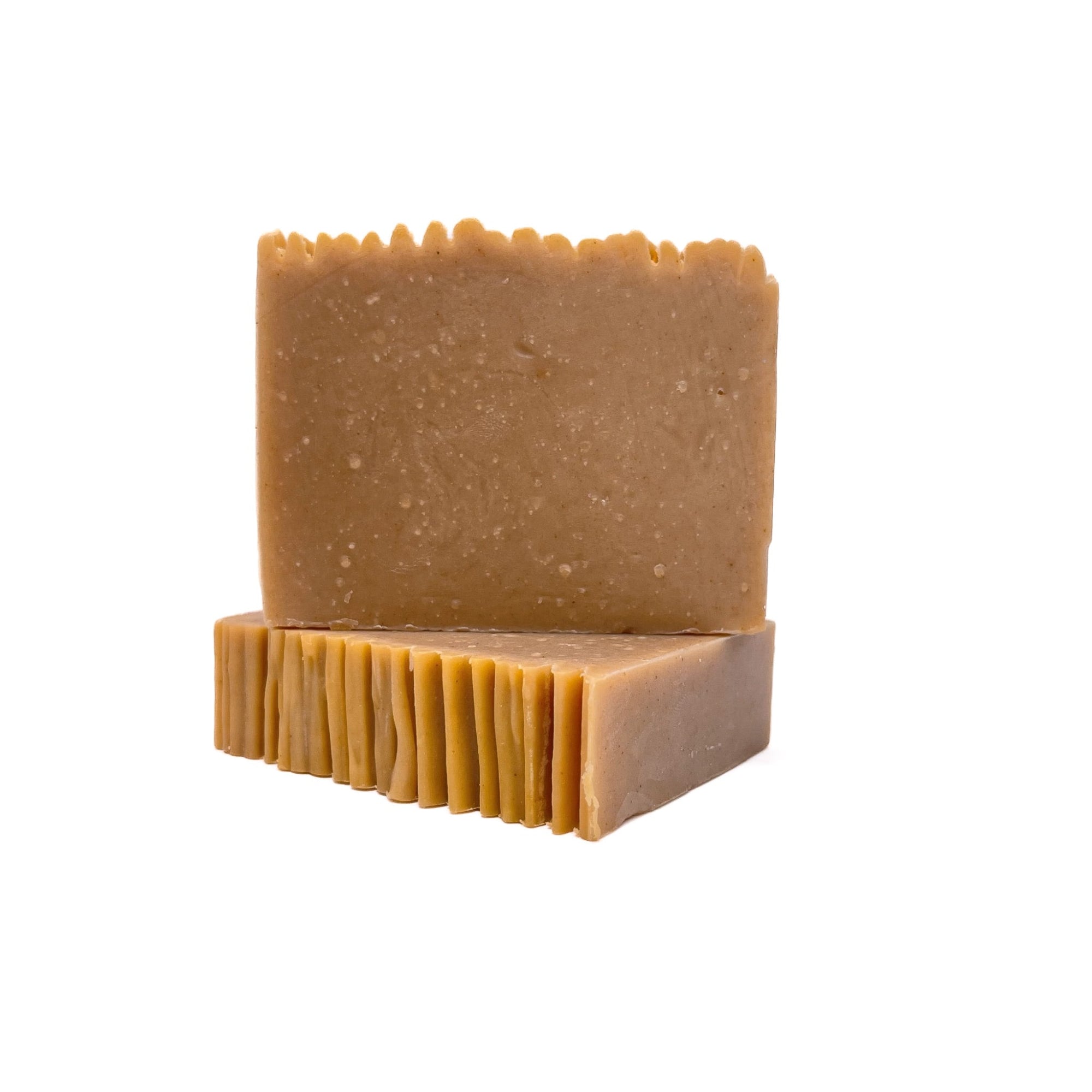 Two bars of creamy yellow colored handmade soap. One upright and one flat to show texture. 