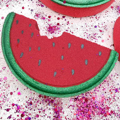 Up-close image of a red and green watermelon bath bomb with hand painted details. 