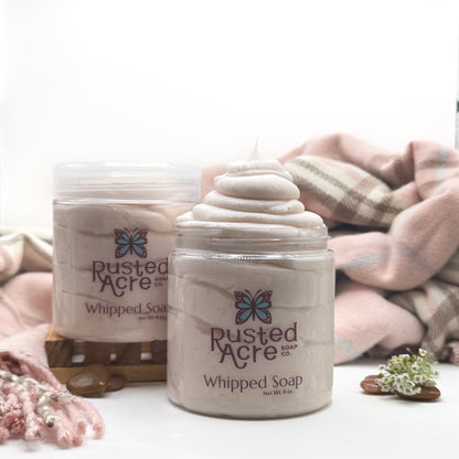 Two jars of Rusted Acre Soap CO’s cashmere whipped soap on a white background with photo props. 