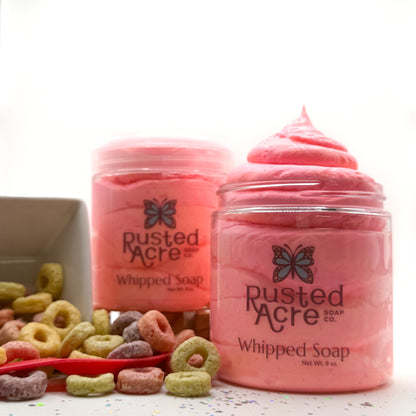 Two jars of Rusted Acre whipped soap with colorful fruity cereal circles in the background.