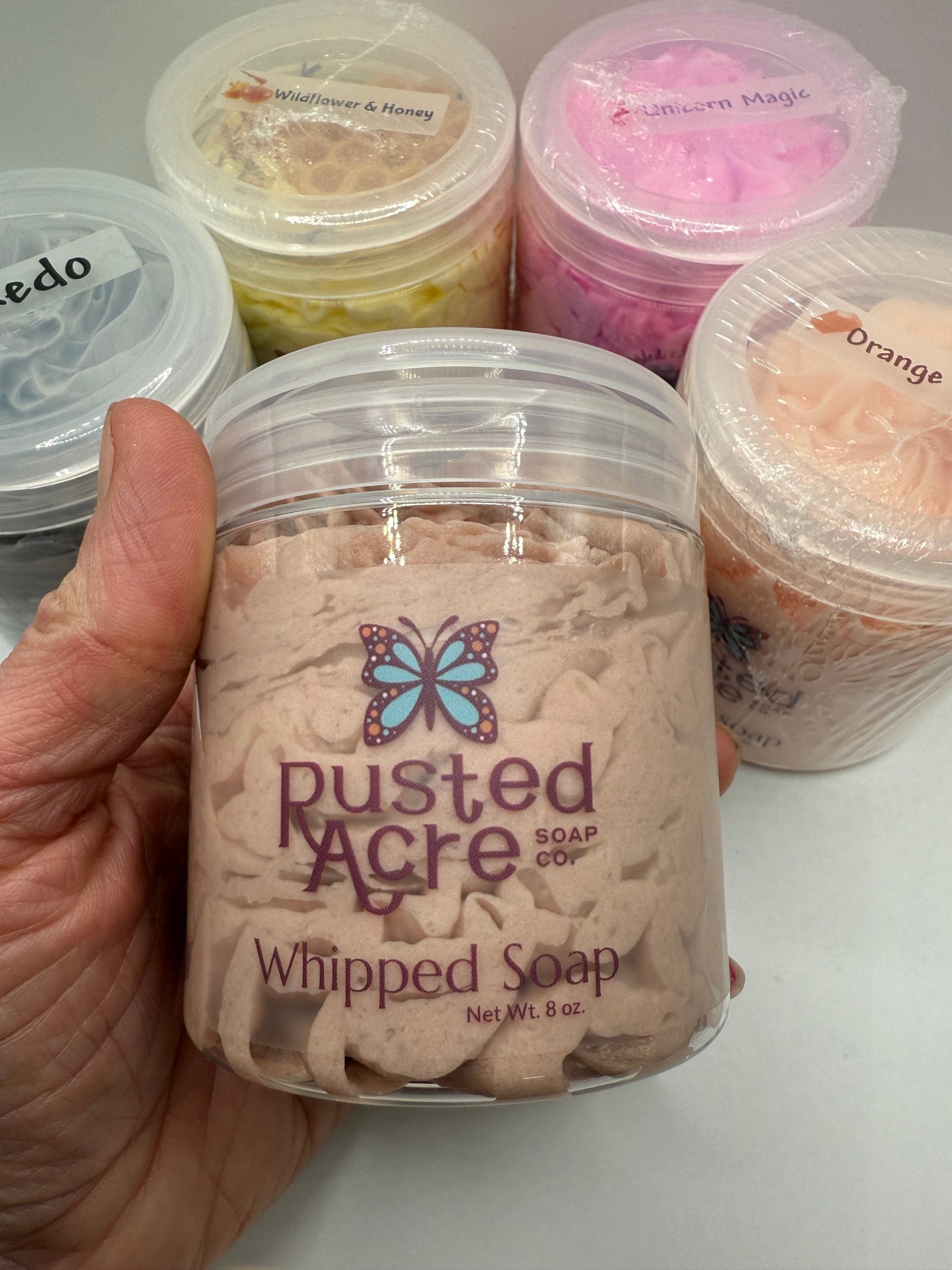 Jar of Rusted Acre Soap Co's whipped soap in hand 