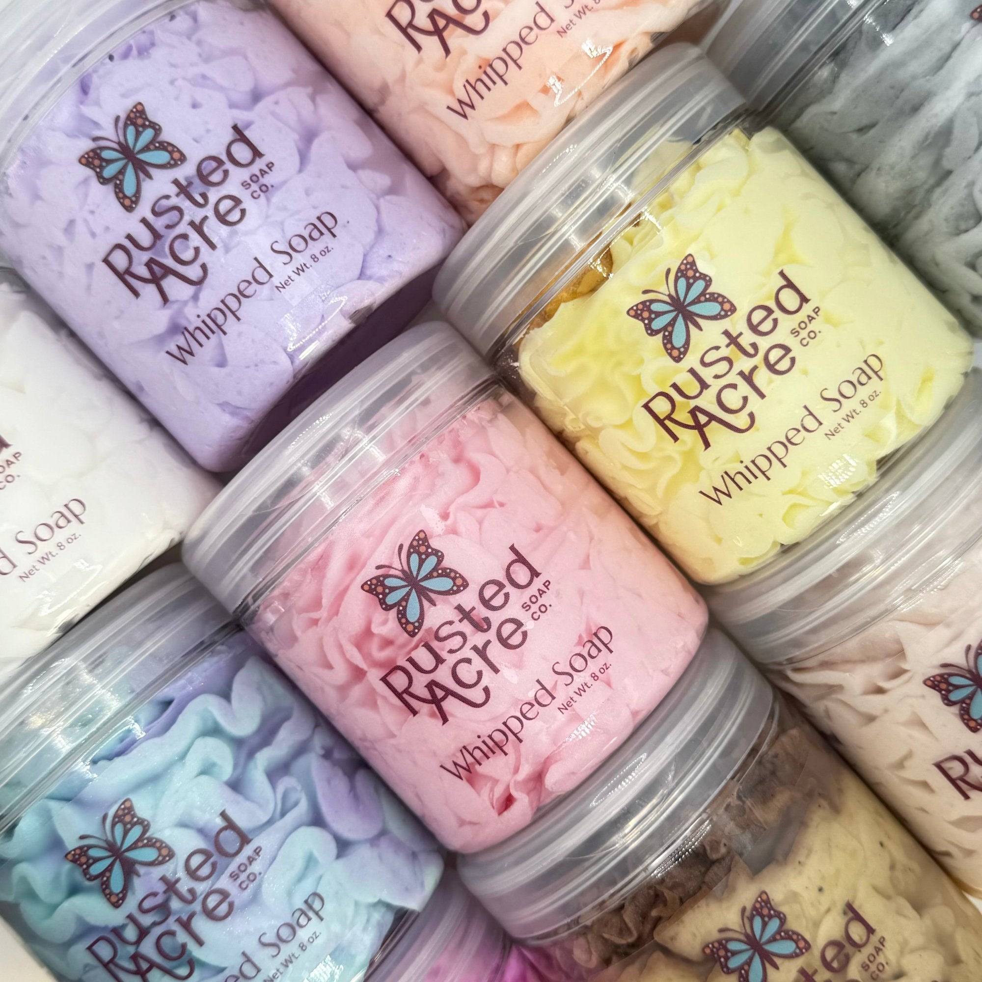 Multiple Jars of colorful Rusted Acre Soap Co's Whipped Soap