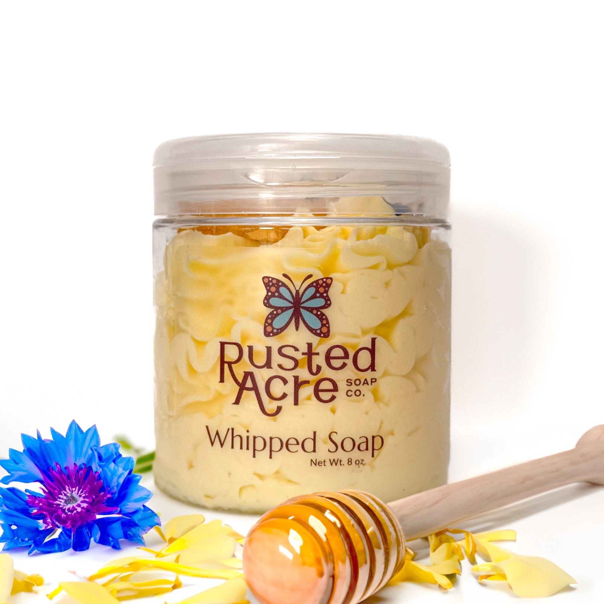 Jar of Rusted Acre Soap Company's vegan wildflower honey whipped soap. Yellow soap in a reusable plastic jar in a lifestyle setting. 