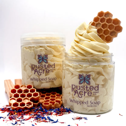 Two jars of Rusted Acre wildflower honey Whipped Soap with honeycomb  on a white background and dried wild flowers